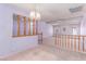 Living room featuring light purple walls, carpeted floors, and a decorative wood railing at 1513 Brocado Ln, Las Vegas, NV 89117