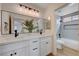 Modern bathroom with a double sink vanity, large mirror, and tiled shower at 1624 Ravanusa Dr, Henderson, NV 89052