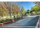 Gated community entrance with mature trees and lush landscaping at 1624 Ravanusa Dr, Henderson, NV 89052