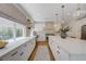 Bright, spacious kitchen featuring white cabinetry, quartz counters, stainless appliances, and decorative lighting at 1624 Ravanusa Dr, Henderson, NV 89052