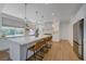 Well-lit kitchen with a large island, stainless appliances, seating, and white cabinets at 1624 Ravanusa Dr, Henderson, NV 89052