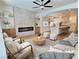Bright living room with fireplace, ceiling fan, modern furnishings, and open access to a gourmet kitchen at 1624 Ravanusa Dr, Henderson, NV 89052