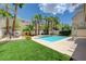 Backyard pool surrounded by lush landscaping including palm trees and a grassy area at 1624 Ravanusa Dr, Henderson, NV 89052
