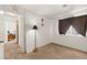 Bedroom features neutral carpet, window, floor lamp, and access to the hallway at 165 Spinnaker Dr, Henderson, NV 89015