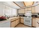 Bright kitchen with white appliances, ample counter space, and a window overlooking the yard at 165 Spinnaker Dr, Henderson, NV 89015