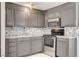 Kitchen featuring gray cabinets, stainless steel appliances, and stylish tile backsplash at 1708 Cedar Ave, Las Vegas, NV 89101