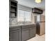 Galley kitchen featuring stainless steel appliances, gray cabinets and tile backsplash at 1708 Cedar Ave, Las Vegas, NV 89101