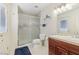 Well-lit bathroom with a glass-enclosed shower, tile flooring, and wood vanity with ample counter space at 1912 Parkchester Dr, Las Vegas, NV 89108