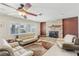Comfortable living room featuring a stone fireplace, ceiling fan, and plush seating at 1912 Parkchester Dr, Las Vegas, NV 89108