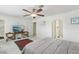 Bright main bedroom with ceiling fan, desk with tv, and an arched doorway to the ensuite bathroom at 1912 Parkchester Dr, Las Vegas, NV 89108