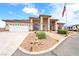 Charming single-story home featuring an arched entrance, desert landscaping, RV parking, and an American flag at 2020 S Omaha Ave, Pahrump, NV 89048