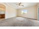Spacious carpeted main bedroom featuring a ceiling fan, natural light, and ensuite bathroom at 2020 S Omaha Ave, Pahrump, NV 89048