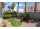 Landscaped backyard with small patch of artificial turf and view of mature landscaping at 203 Sea Rim Ave, Las Vegas, NV 89148