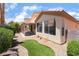 View of the home's rear exterior, patio and landscaped backyard with small patch of artificial turf at 203 Sea Rim Ave, Las Vegas, NV 89148
