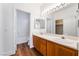 Ensuite bathroom features double sinks, wood cabinets, large mirror, and shower over tub at 203 Sea Rim Ave, Las Vegas, NV 89148