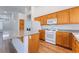 Bright open kitchen features wood cabinets, white appliances, island and granite countertops at 203 Sea Rim Ave, Las Vegas, NV 89148