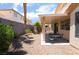 The covered patio has a table and chairs, and has a view of the landscaped backyard at 203 Sea Rim Ave, Las Vegas, NV 89148