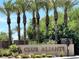 Scenic view of the Club Aliante entrance featuring lush landscaping and mature palm trees at 2117 Bay Thrush Way, North Las Vegas, NV 89084