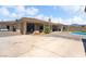 Backyard features an outdoor patio, rock features, a small putting green, and a sparkling pool at 2181 E Winery Rd, Pahrump, NV 89048