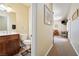 Bathroom view showcases a dark vanity and extends to a hallway with carpet and artwork at 2181 E Winery Rd, Pahrump, NV 89048