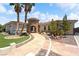 Stunning home featuring a stone tower entrance, palm trees, tile roof, and beautifully landscaped front yard at 2181 E Winery Rd, Pahrump, NV 89048