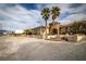 Charming single-story home with unique stone accents, a tile roof, palm trees, and a desert landscape at 2181 E Winery Rd, Pahrump, NV 89048