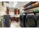 Well-equipped laundry room offers modern washer, dryer, storage shelves, and sink for efficient cleaning at 2181 E Winery Rd, Pahrump, NV 89048