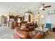 Spacious living room with a leather sofa, ceiling fan, and open floor plan into the kitchen at 2181 E Winery Rd, Pahrump, NV 89048