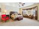 Cozy primary bedroom with a sitting area and large window with decorative drapes and neutral-toned decor at 2181 E Winery Rd, Pahrump, NV 89048