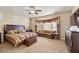 Spacious main bedroom featuring a sitting area and a large window with decorative drapes and neutral-toned decor at 2181 E Winery Rd, Pahrump, NV 89048