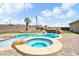 A stunning backyard with a custom pool, rock waterfall, spa, and carefully placed greenery at 2181 E Winery Rd, Pahrump, NV 89048