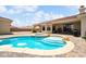 Beautiful backyard with a sparkling pool, spa, and covered patio, ideal for entertaining at 2181 E Winery Rd, Pahrump, NV 89048