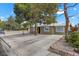 Single-story home with desert landscaping, mature trees, and a paved driveway at 2408 Berkley Ave, Las Vegas, NV 89101