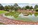 Wide view of a community pond with lush green water surrounded by manicured landscaping, plants and mature trees at 3201 Beacon Shores Cir, Las Vegas, NV 89117