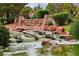 Scenic pond view with a rock waterfall, lush greenery, and birds, creating a tranquil and inviting outdoor space at 3201 Beacon Shores Cir, Las Vegas, NV 89117