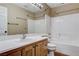 Bright bathroom featuring a vanity with a single sink, toilet, and a shower-tub combination with white tile surround at 3717 Shanagolden St, Las Vegas, NV 89129