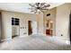 Light-filled bedroom with ensuite bathroom, neutral carpet, and ceiling fan, offering a tranquil retreat at 3717 Shanagolden St, Las Vegas, NV 89129
