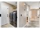 Hallway view with tile floors, a nearby washer and dryer, leading into another room with carpeted floors at 3717 Shanagolden St, Las Vegas, NV 89129