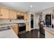 Stylish kitchen with stainless steel appliances, tile backsplash, and access to laundry area at 3717 Shanagolden St, Las Vegas, NV 89129