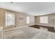 Bright living room featuring carpet, wood flooring, and large windows, perfect for relaxing or entertaining at 3717 Shanagolden St, Las Vegas, NV 89129