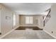 Open-concept living room with carpet, wood flooring, staircase, and natural light from windows at 3717 Shanagolden St, Las Vegas, NV 89129
