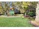Community playground nestled among mature trees and green lawn, with picnic tables nearby at 3717 Shanagolden St, Las Vegas, NV 89129