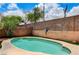 Relaxing backyard with a pristine pool, brick fencing, string lights, and a beautifully landscaped perimeter at 3717 Shanagolden St, Las Vegas, NV 89129