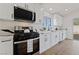 Modern kitchen featuring stainless steel appliances, white cabinets, and quartz countertops at 383 Virginia Lake Ave, Henderson, NV 89015