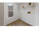 Bright laundry room featuring wood-look floors, a window, and practical shelving for storage and organization at 383 Virginia Lake Ave, Henderson, NV 89015