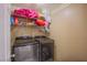 Well-equipped laundry room with side-by-side washer and dryer and storage shelving at 4429 E Azure Ave, Las Vegas, NV 89115