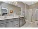 Bathroom featuring a double vanity, large mirror, walk-in shower, and tile flooring at 4537 Cloudrest Peak St, North Las Vegas, NV 89031