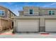 Townhome featuring an attached two-car garage with neutral stucco and stone accents at 4537 Cloudrest Peak St, North Las Vegas, NV 89031