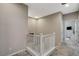 Well-lit hallway landing with a white banister and plush carpet, leading to bedrooms at 4537 Cloudrest Peak St, North Las Vegas, NV 89031