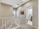 Upstairs hallway with white railing, carpet flooring, and bathroom entrance at 4537 Cloudrest Peak St, North Las Vegas, NV 89031